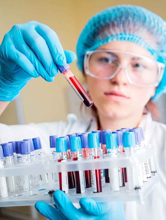 female holds blood tube from rack