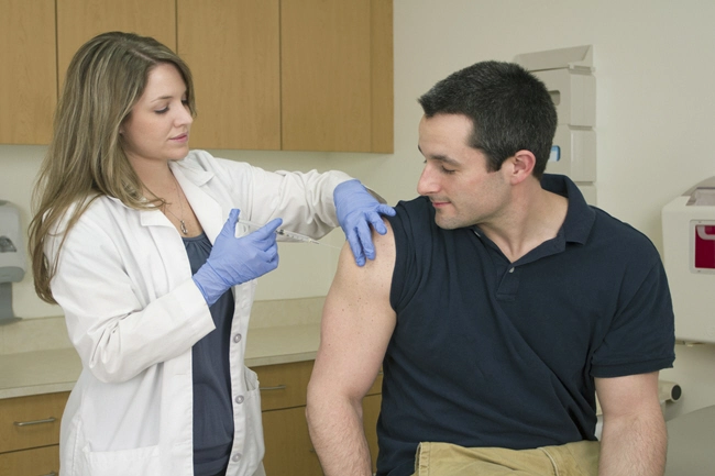 female medical professional takes blood sample from male patient 2