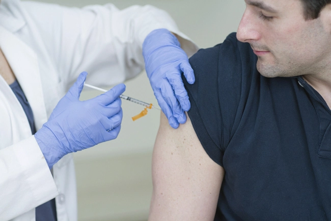 female medical professional takes blood sample from male patient close up