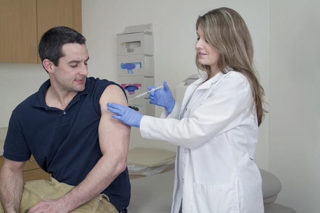 female medical professional takes blood sample from male patient