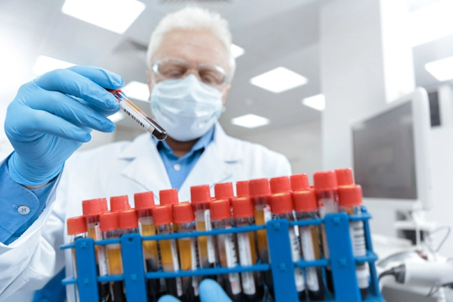 male doctor holding rack of blood samples