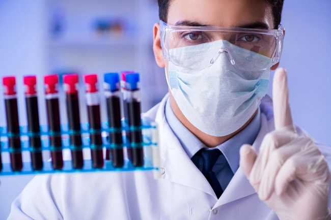 male doctor holds rack of test tubes