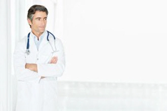 male doctor with arms folded looking at copy space xs