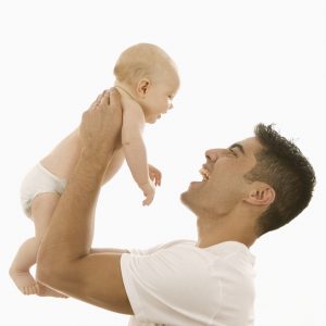 father holding up infant daughter 300x300
