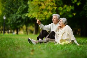 Elderly couple by the tree in the park 300x200