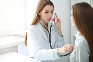 Young female doctor using stethoscope 300x200