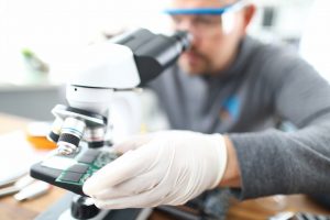 close up of gadgets problems fixing with soldering man looking at HGH circuit board details through 300x200