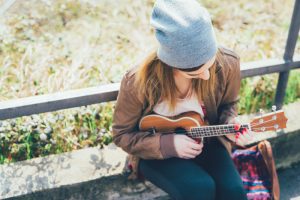 graphicstock young woman in the city playing ukulele busker musician composer concept_ SBI 304213511 1 300x200