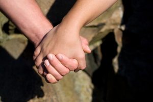 a closeup of a man and woman holding hands SBI 301049746 300x200